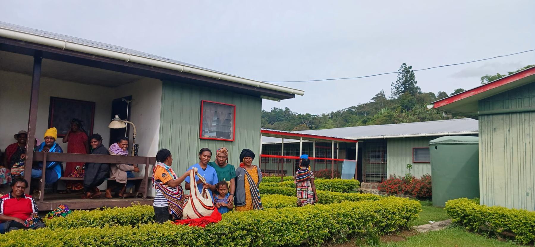Group of people in front of Kaupena Health Centre sign